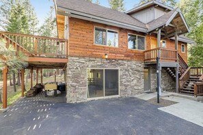 A two-story log cabin with a stone foundation, a balcony, and a staircase leading to the upper level. - Majestic Mountain - Big Trees Village (Dorrington)
