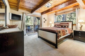 Ein Schlafzimmer mit Bett, Fernseher, Schreibtisch und Fenster.