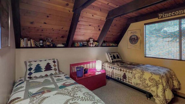 Una camera da letto con due letti, un comodino rosso e una finestra con vista.