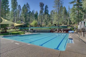 A swimming pool with clear blue water, surrounded by a fence and trees. - Stiles Mountain Hideaway - Blue Lake Springs (Arnold)