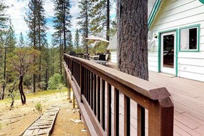 A wooden deck with outdoor furniture, surrounded by a forest. - Stiles Mountain Hideaway - Blue Lake Springs (Arnold)
