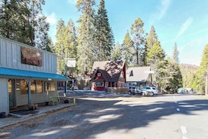 A small-town setting with a diner, a red-roofed building, and a parking lot. - Sparrow Cove - East Village (Shaver Lake)