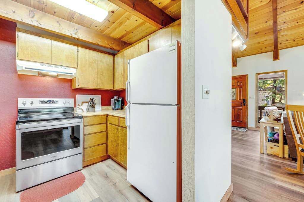 Une cuisine avec des meubles en bois, un four en acier inoxydable et un réfrigérateur blanc.