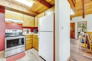 A kitchen with wooden cabinets, a stainless steel oven, and a white refrigerator.
