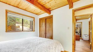 Ein Schlafzimmer mit einem Bett, einem Fenster und einer Holztür.