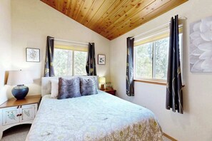 A bedroom with a bed, two bedside tables, a window, and curtains. - Hilltop Chalet - Blue Lake Springs (Arnold)