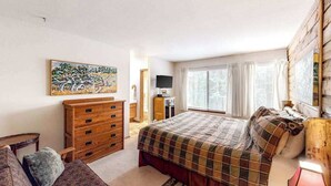 A bedroom with a bed, dresser, TV, and artwork. - Big Mountain, Little Condo - Huntington Lake (Lakeshore)