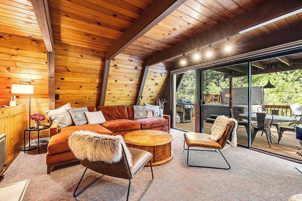 A cozy interior with a wooden ceiling, a sofa, a chair, and a round coffee table.