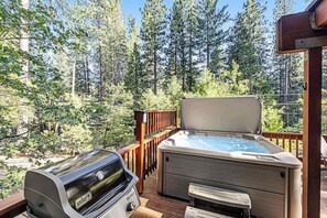 Eine Terrasse mit einem Weber-Grill und einem Whirlpool.