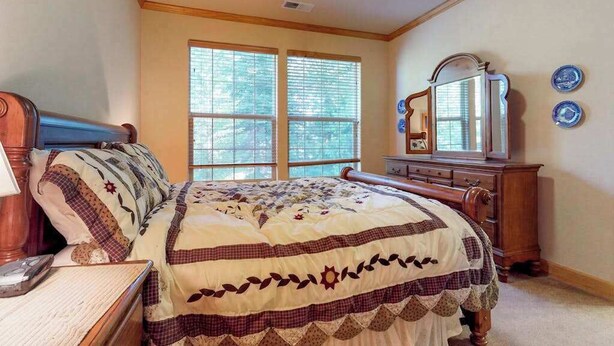 A bedroom with a bed, dresser, mirror, and two windows. - New England Cottage - Ockenden Ranch (Shaver Lake)