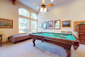 A pool table in a room with large windows and artwork on the walls. - New England Cottage - Ockenden Ranch (Shaver Lake)