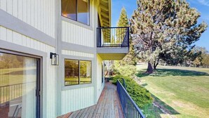 Un edificio de dos plantas con una terraza de madera y un balcón.