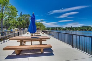 A riverside picnic area with benches and a blue umbrella.