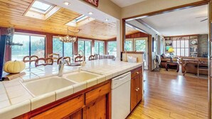 Una cocina amplia con armarios de madera, una isla grande con fregadero y vistas al exterior.