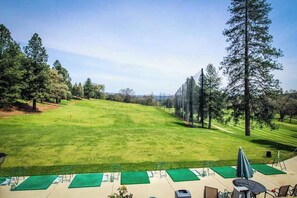 A golf course with a clear view of the fairway, a putting green, and a clubhouse with outdoor seating. - The Cub Inn - Groveland (Groveland)