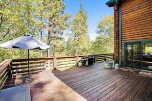 A wooden deck with a grill and barbecue, surrounded by trees. - The Cub Inn - Groveland (Groveland)
