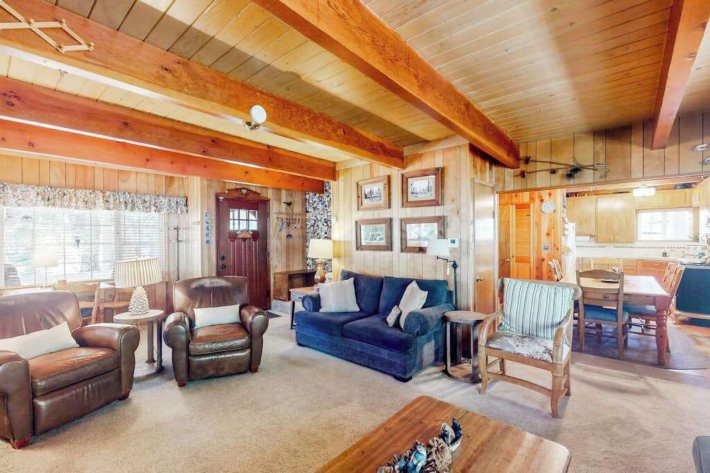 A cozy living room with leather sofas, a wooden coffee table, and a dining area with a table and chairs.