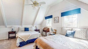 A bedroom with two beds, a ceiling fan, a window with blue valance, and a wall with a framed picture. - Mountain Memories - Musick Meadows (Shaver Lake)