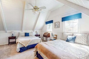 A bedroom with two beds, a ceiling fan, a window with blue valance, and a wall with a framed picture. - Mountain Memories - Musick Meadows (Shaver Lake)