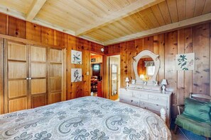 A wooden-paneled room with a bed, dresser, and a mirror. - Mountain Memories - Musick Meadows (Shaver Lake)