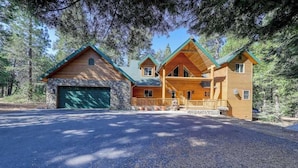 A two-story log cabin with a stone foundation, a covered front porch, and a garage. - Pinnacle Point - Granite Ridge (Shaver Lake)