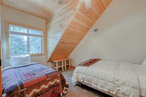 A bedroom with two beds, a sloped ceiling, and a window. - Pinnacle Point - Granite Ridge (Shaver Lake)