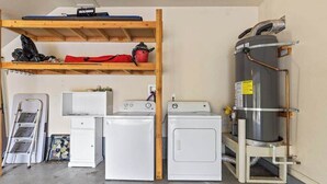 A laundry room with two washing machines, a dryer, and a large water heater. - Big Creek Hideaway - Pine Mountain Lake (Groveland)