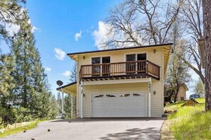 A two-story house with a balcony, a garage, and a satellite dish. - Big Creek Hideaway - Pine Mountain Lake (Groveland)