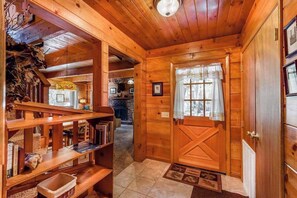 Un intérieur en bois avec une porte, des étagères et une cheminée.