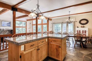 A kitchen with wooden cabinets, granite countertops, and a central island. - Alder Hill Hideaway - Wildflower Village (Shaver Lake)