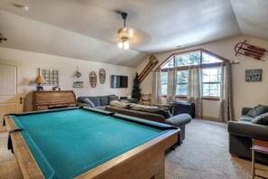 A pool table in a room with a ceiling fan, a sofa, and a television. - Alder Hill Hideaway - Wildflower Village (Shaver Lake)