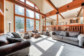 A spacious living room with large windows, a fireplace, and a cozy seating area. - Alder Hill Hideaway - Wildflower Village (Shaver Lake)