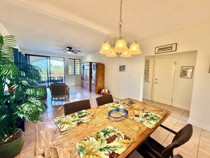 A dining area with a wooden table, chairs, and a chandelier. - Sunset Oasis - 2Br Beach Front Condo (Christiansted)