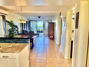 A spacious kitchen with a dining area, a ceiling fan, and a view to the outside. - Sunset Oasis - 2Br Beach Front Condo (Christiansted)