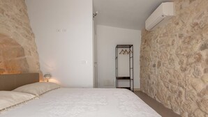 A bedroom with a bed, a wardrobe, and an air conditioning unit. - Pajara Donna Piccinni by BarbarHouse (Carpignano Salentino)