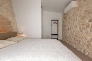 A bedroom with a bed, a wardrobe, and an air conditioning unit. - Pajara Donna Piccinni by BarbarHouse (Carpignano Salentino)