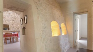A stone-walled interior with a dining area, a wooden table, and chairs. - Pajara Donna Piccinni by BarbarHouse (Carpignano Salentino)
