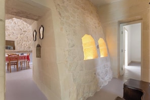 A stone-walled interior with a dining area, a wooden table, and chairs. - Pajara Donna Piccinni by BarbarHouse (Carpignano Salentino)