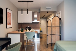 A modern kitchen with a dining area, a sofa, and a partition with a woven design. - Gallo Studio  by BarbarHouse (Bari)