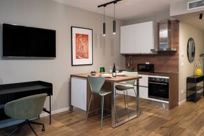 A modern kitchen with a dining area, a flat-screen TV, and a framed artwork on the wall. - Gallo Studio  by BarbarHouse (Bari)
