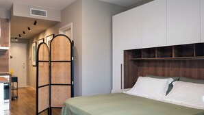 A bedroom with a bed, a wardrobe, a partition, and a small table. - Gallo Studio  by BarbarHouse (Bari)