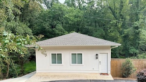 A single-story house with a gabled roof, a front door, and two windows.