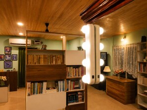 A room with wooden bookshelves, a vanity with lights, and a mirror.