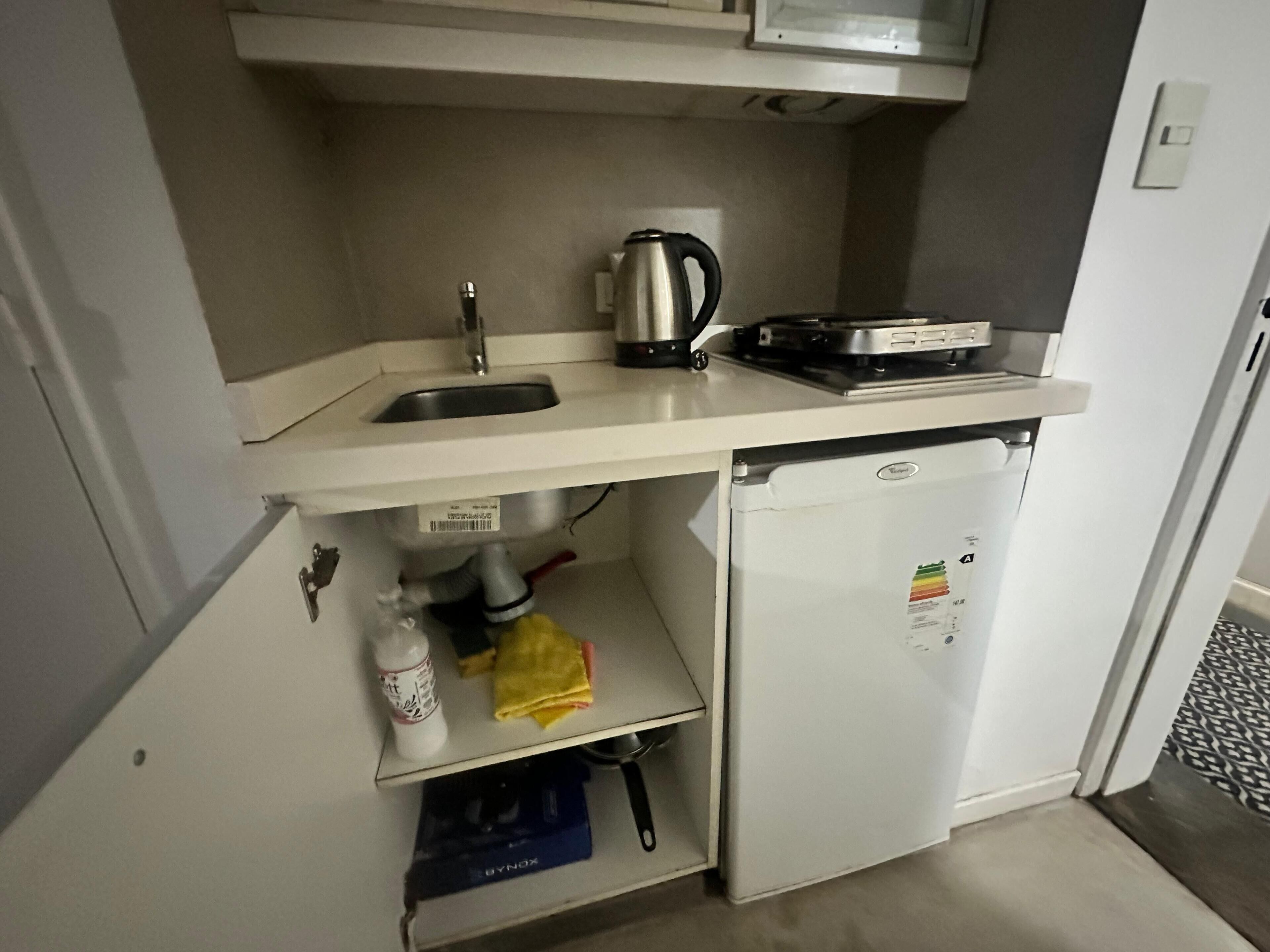 Pieni, käytännöllinen keittiönurkkaus, jossa on pesuallas, vedenkeitin, leivänpaahdin ja jääkaappi.