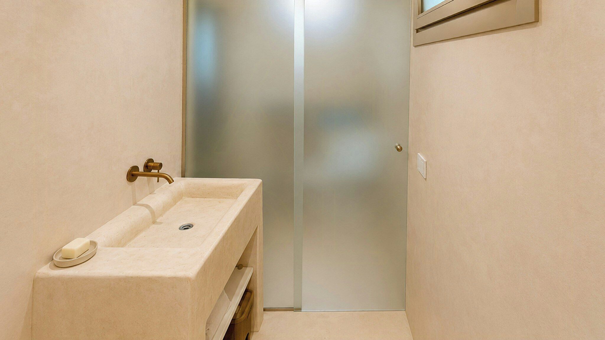 Un bagno con un lavandino, uno specchio e una porta che dà su un'altra stanza.