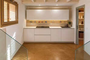 A modern kitchen with a built-in oven, a sink, and a countertop with decorative items. - Restored cottage with views over Vendicari (Noto)