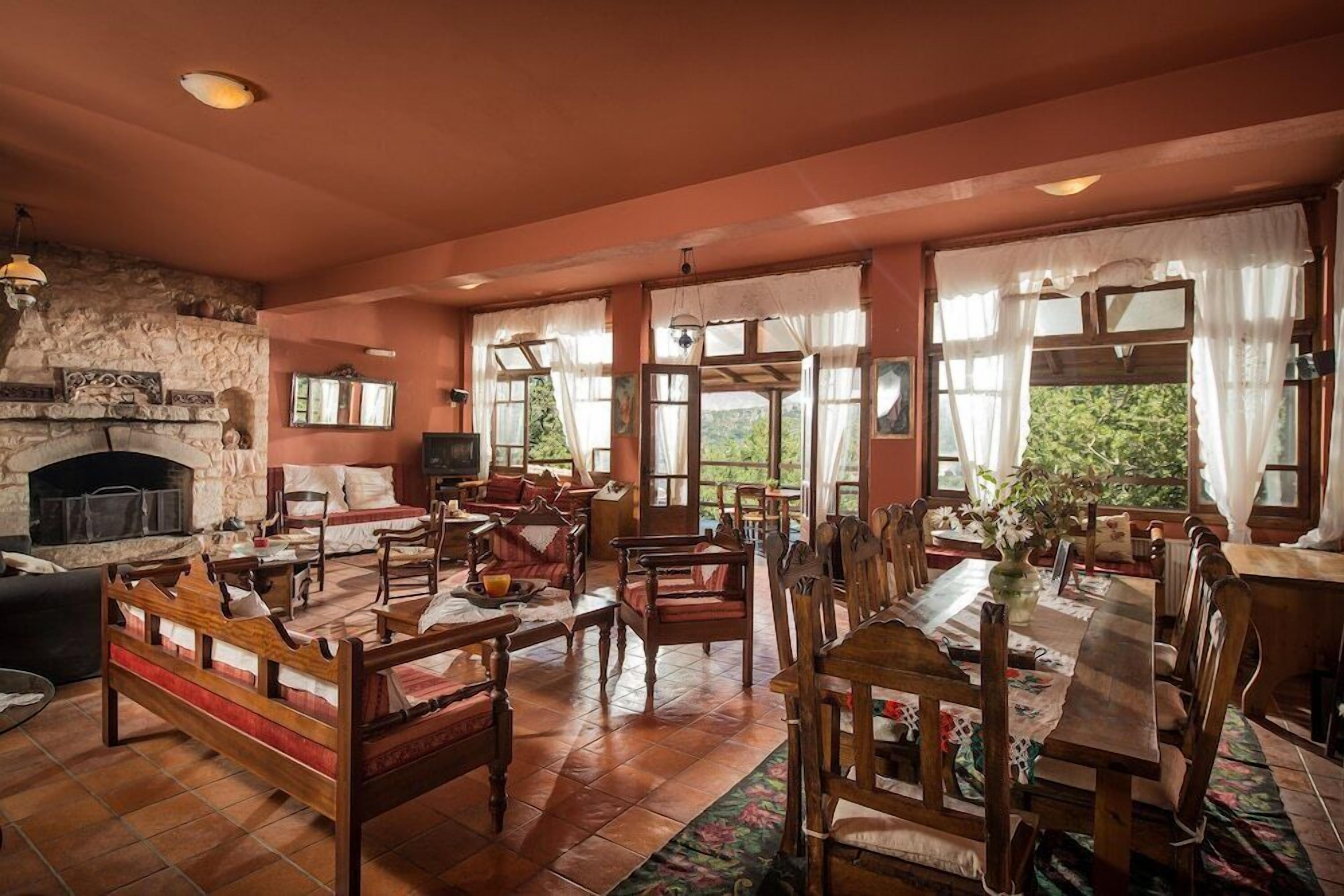 Un salón amplio con chimenea, varias zonas de estar y ventanas grandes.