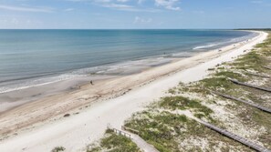 A beach with a wooden boardwalk leading to the shore, sandy beach, and calm sea. - Pet-Friendly Beach House with Ocean Views (Port St. Joe)