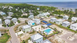 A coastal residential area with houses, a tennis court, and a swimming pool. - Pet-Friendly Beach House with Ocean Views (Port St. Joe)