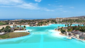 A resort with a large pool, beachfront, and a view of the ocean. - Beachfront 2BR Condo with Hot Tub at Diamante Dunes (Cabo San Lucas)